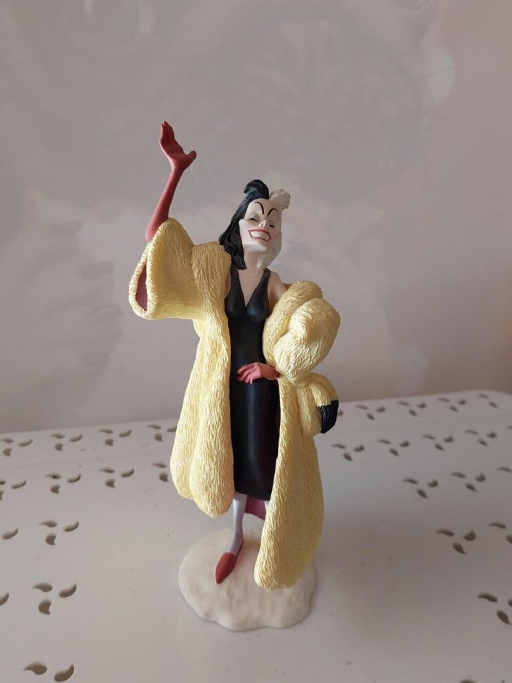 Disney Cruella De Vil figurine from 101 Dalmatians. Yellow coat, black dress, re